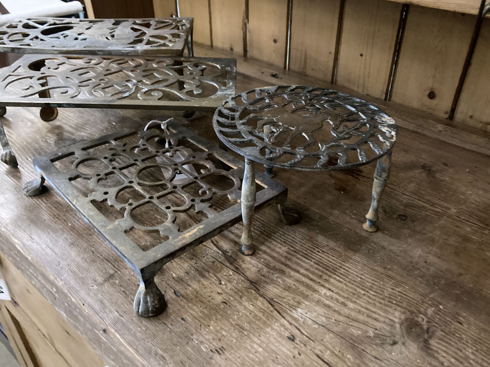 Five Victorian and later brass trivets, largest width 26cm, height 14cm